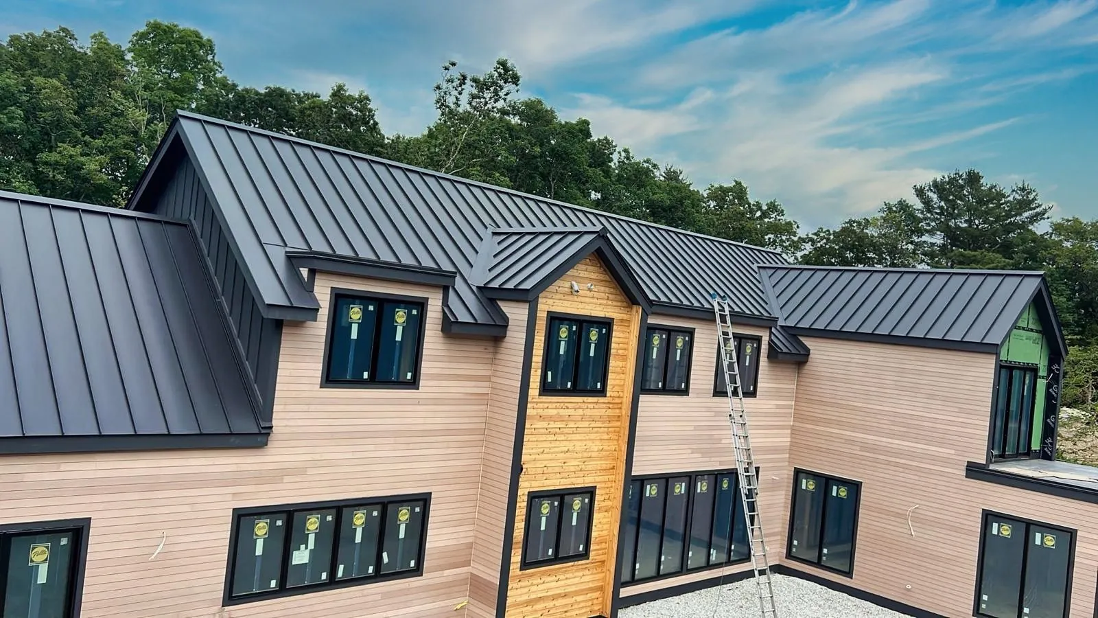 Standing seam metal roof on a two-story home with wood siding