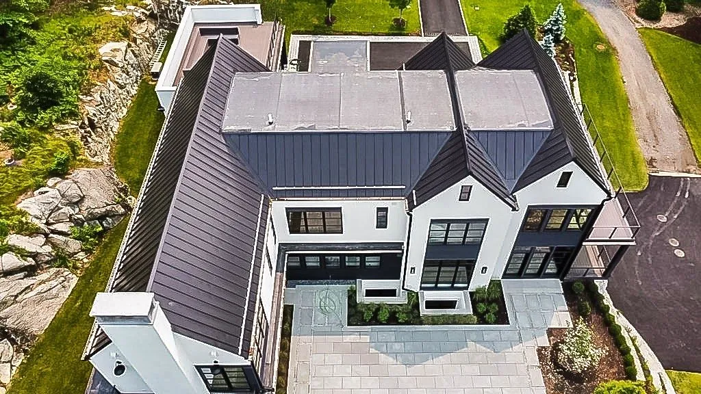 Aerial view of a dark standing seam roof on a modern farmhouse