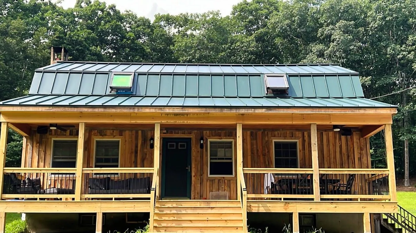 Green standing seam over a cabin porch