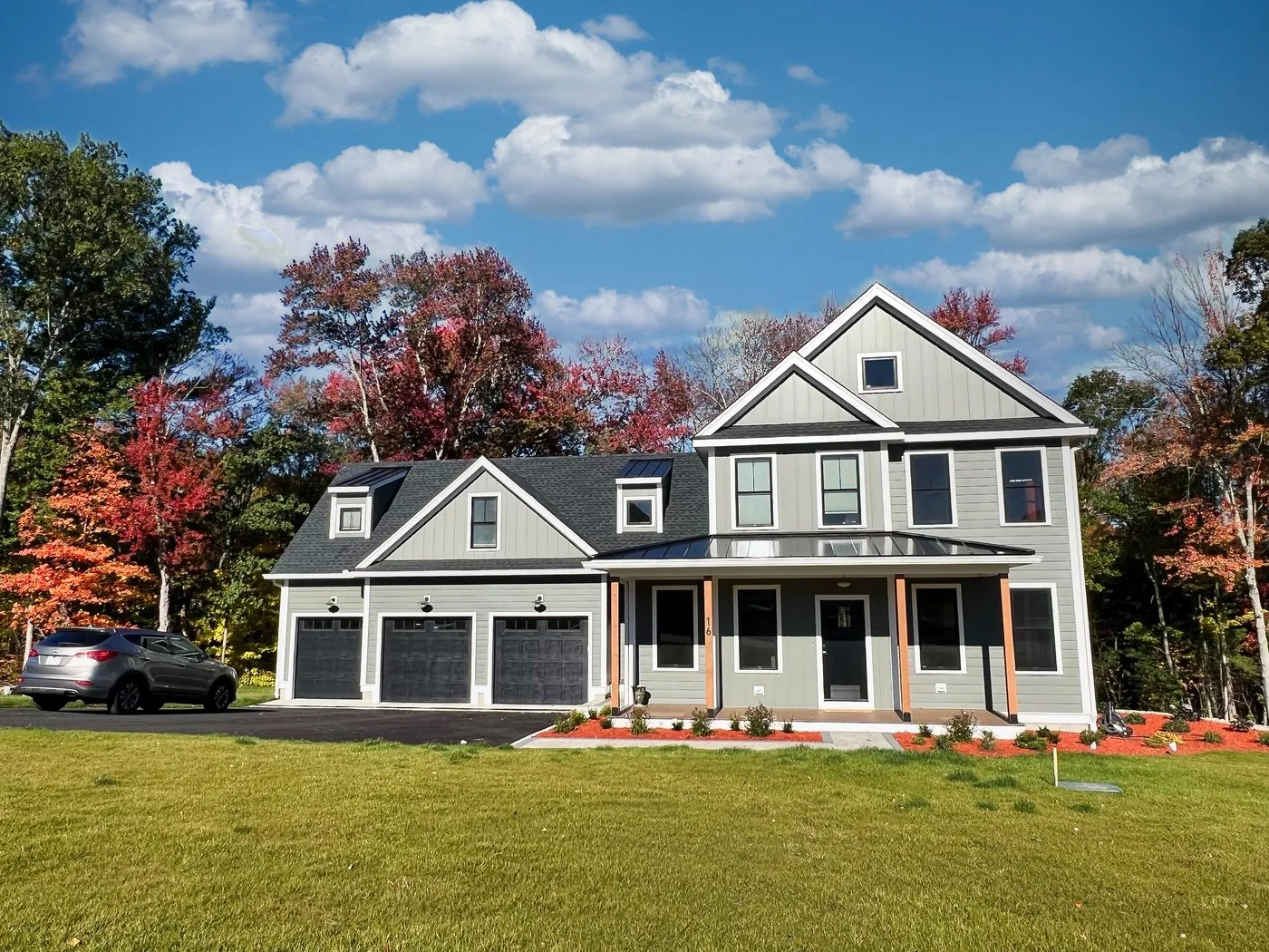 Farmhouse with a standing seam porch roof in the fall